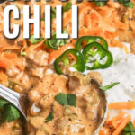 Keto White Chicken Chili in a pot and with a ladle taking a scoop out and writing