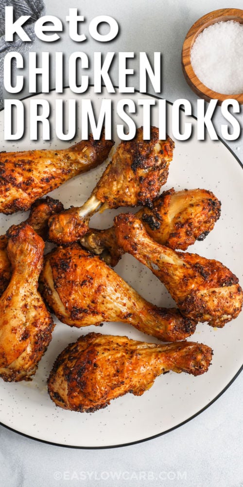 These crispy low-carb chicken drumsticks are seasoned with smoked paprika, garlic, and oregano, then baked at high heat for juicy meat and golden skin. This recipe is great for weeknight dinners or meal prep because it requires only a few ingredients and very little cleanup. Pair these drumsticks with roasted vegetables or a fresh salad for an easy keto-friendly meal that tastes amazing and keeps you full. #easylowcarb plate of Oven Baked Chicken Drumsticks with writing