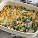 Spinach Casserole in a casserole dish with a part taken out