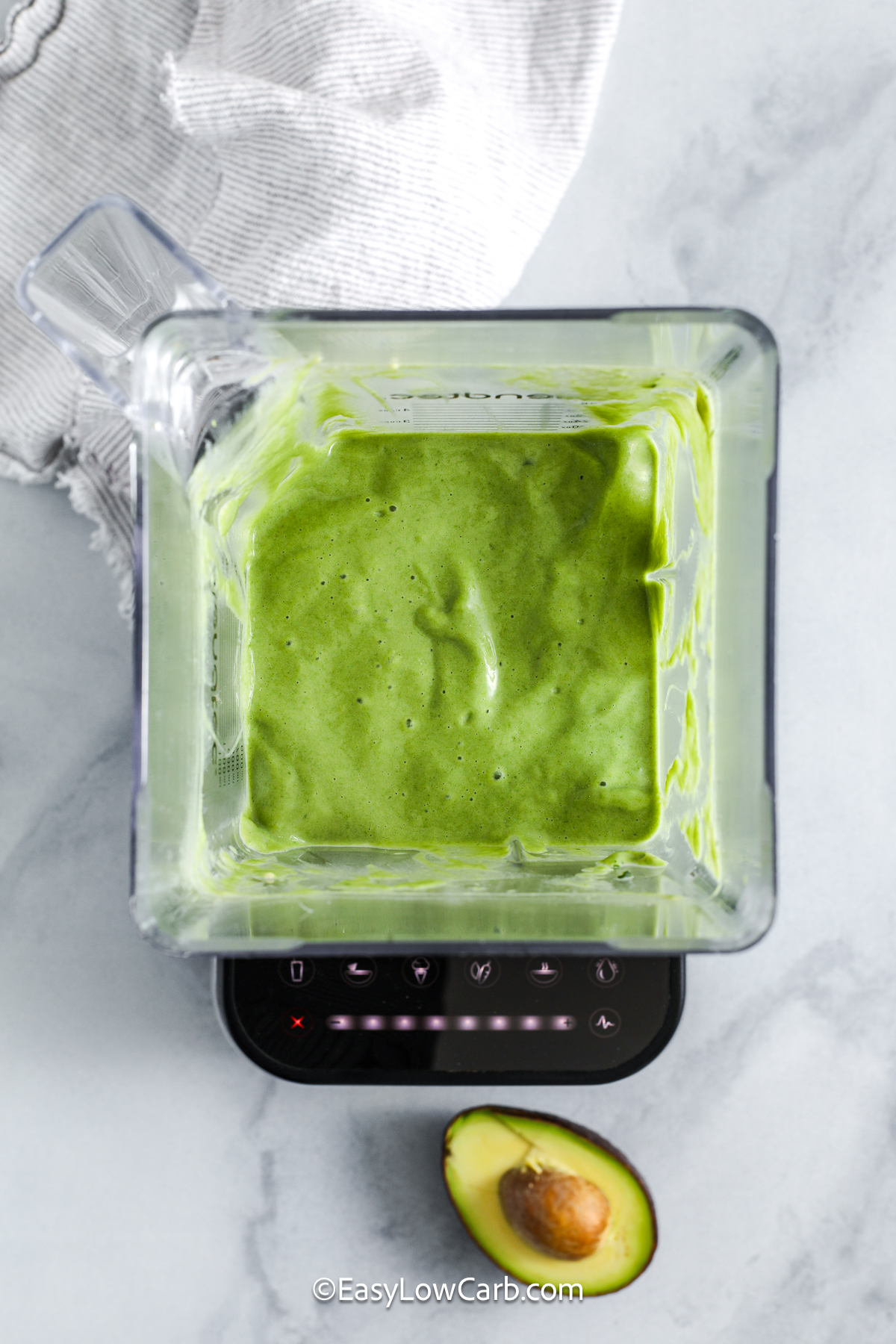 This avocado smoothie combines creamy avocado, fresh or frozen spinach, almond milk, and vanilla protein powder for a nourishing drink that comes together in minutes. Ice adds a refreshing chill, making it great for warm days or post-workout recovery. The ingredients blend smoothly and create a balanced mix of flavor and nutrition. It is a great option for busy mornings or healthy snacking throughout the day. #easylowcarb avocado smoothie in a blender