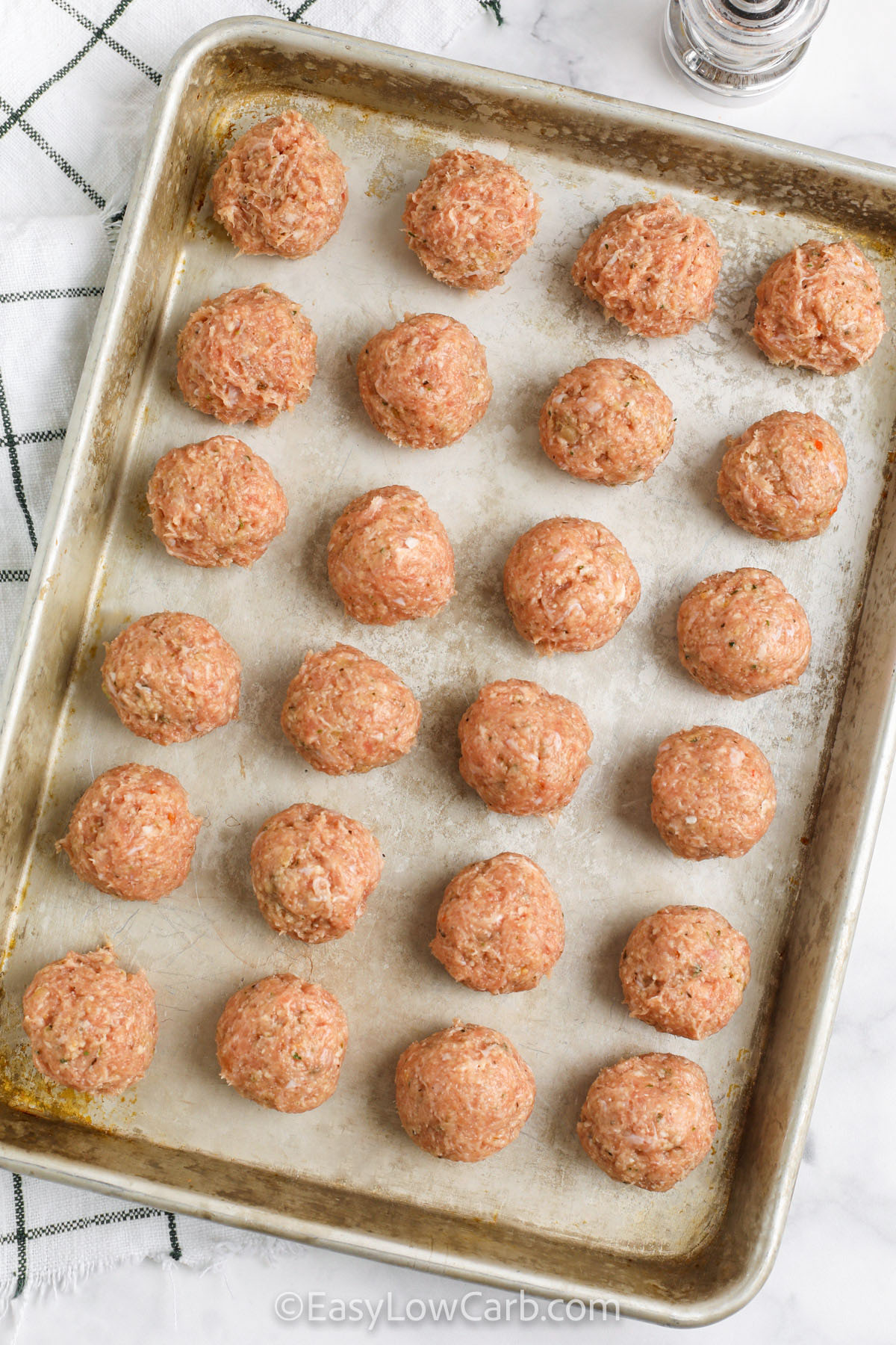 If you love easy sheet pan dinners, these baked chicken meatballs are a great way to use ground chicken. The mixture comes together quickly with garlic, parmesan, and almond flour, then bakes into perfectly browned meatballs that stay moist. Pair them with roasted vegetables, spaghetti squash, or zucchini noodles for a full low carb meal. Leftovers store and reheat well, so they are ideal for make ahead lunches and freezer meals. #easylowcarb Chicken Meatballs on a sheet pan before cooking