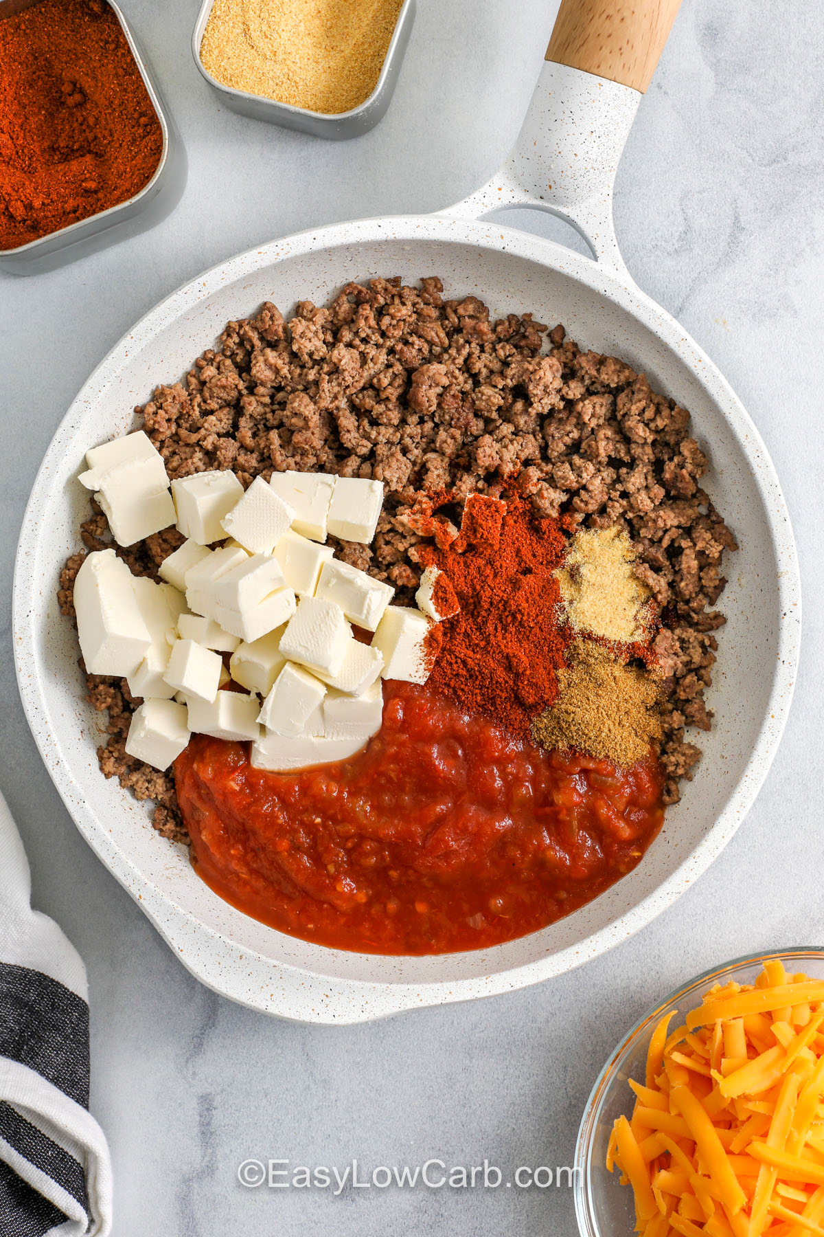 This Chili Cheese Dip is a cozy, melty skillet dip made with seasoned ground beef, low-carb salsa, cream cheese, and shredded cheddar. It comes together quickly and tastes like a beefy queso without needing processed cheese. Serve it warm with low-carb tortilla chips, cheese crisps, or crunchy veggies like bell peppers and celery. Keep the heat on low while melting the dairy in order to get the smoothest, creamiest texture. #easylowcarb adding cream cheese , salsa and seasonings to ground beef to make Chili Cheese Dip