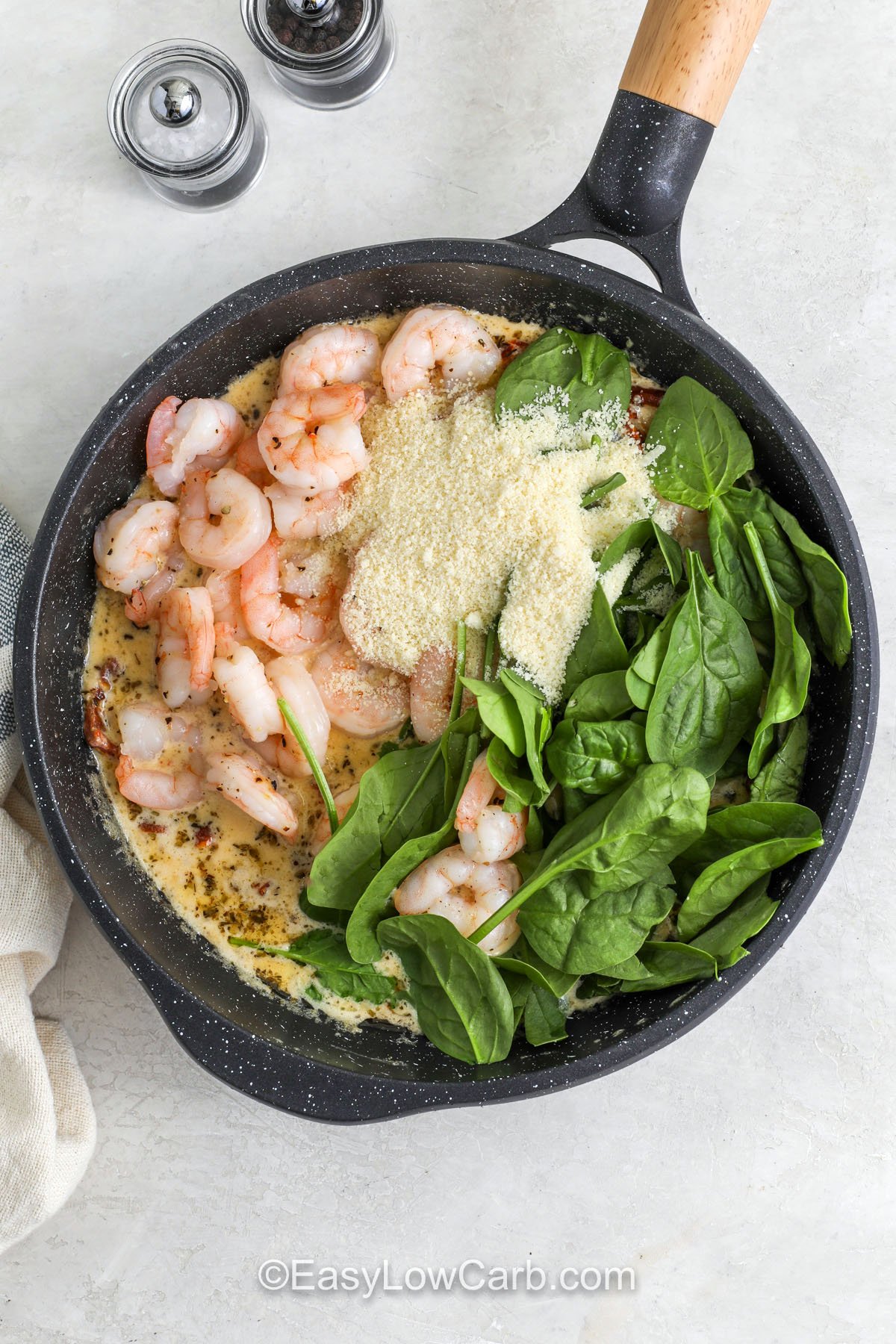 Creamy Tuscan shrimp is an easy way to turn shrimp into a comforting, creamy dinner. Sear shrimp first for better flavor, then simmer the cream sauce until it thickens slightly before stirring in spinach and Parmesan. The sun-dried tomatoes add bold Mediterranean flavor without extra work. It is delicious over zoodles, cauliflower rice, or alongside a crisp salad. #easylowcarb adding ingredientsto pan to make Creamy Tuscan Shrimp