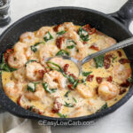 pan of Creamy Tuscan Shrimp with a spoon