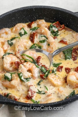 pan of Creamy Tuscan Shrimp with a spoon