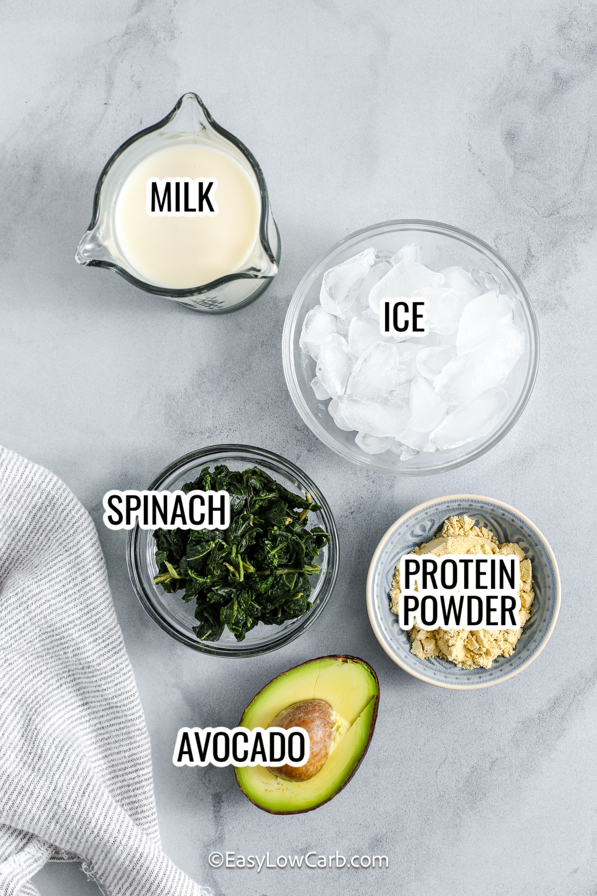 This creamy avocado smoothie blends ripe avocado with fresh spinach, almond milk, and vanilla protein powder. It makes a smooth and nourishing drink with a cool, refreshing flavor. It comes together in minutes. Perfect for a quick breakfast or post-workout snack, this smoothie offers healthy fats and protein in one easy blend. It is a simple, low carb option that delivers flavor and satisfaction in every sip. #easylowcarb ingredients for avocado smoothie including avocado, spinach, milk, ice, and protein powder