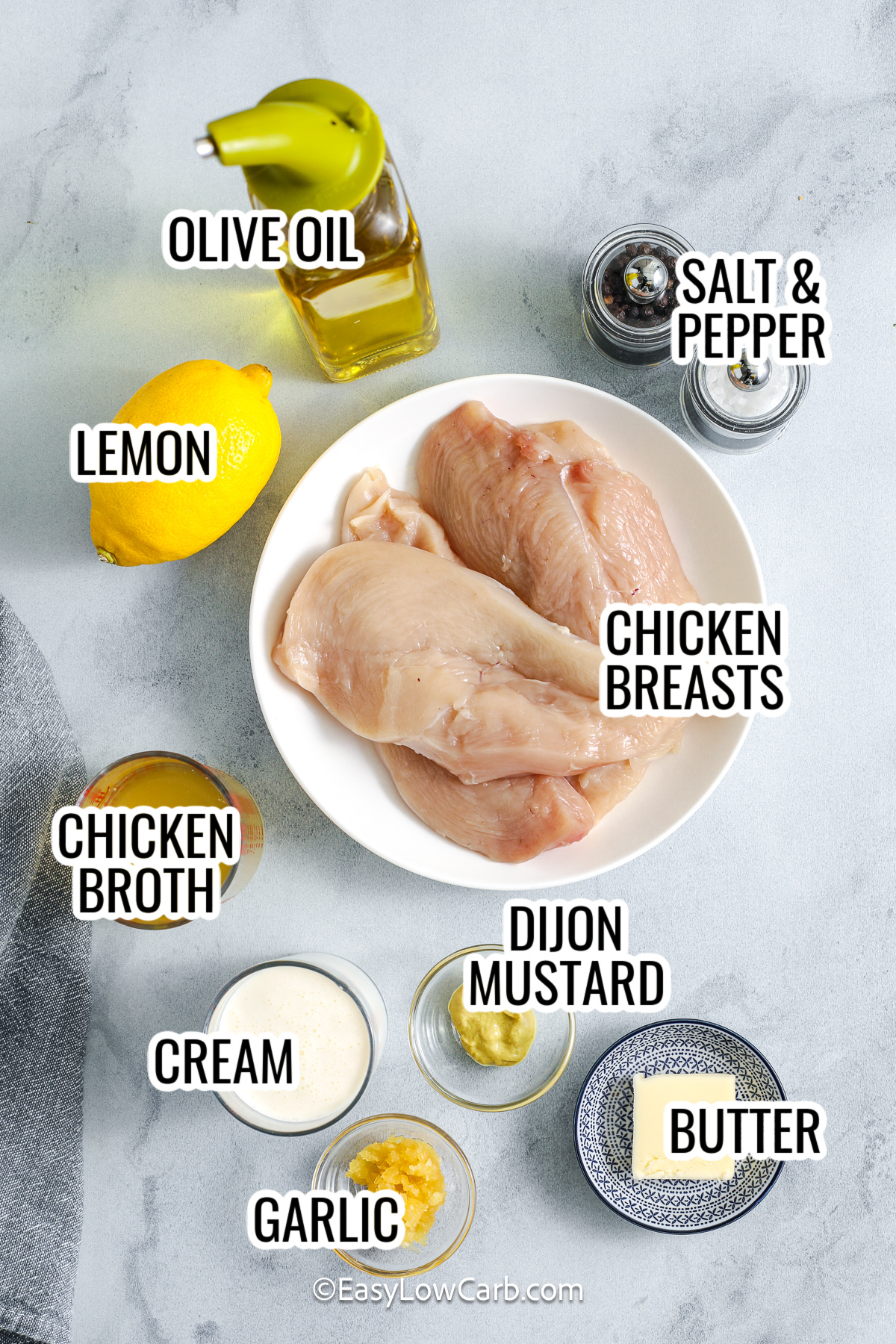 This creamy lemon chicken recipe is a simple one skillet dinner that feels like a restaurant meal but stays low carb. Thin chicken cutlets are seared until golden, then simmered in a velvety sauce made with heavy cream, chicken broth, garlic, Dijon, and plenty of fresh lemon zest and juice. The sauce is bright and tangy yet rich enough to coat every bite. Serve it with cauliflower rice, zoodles, or roasted vegetables for an easy weeknight meal. #easylowcarb ingredients for creamy lemon chicken including olive oil, salt and pepper, lemon, chicken broth, chicken breasts, dijon mustard, cream, garlic, butter