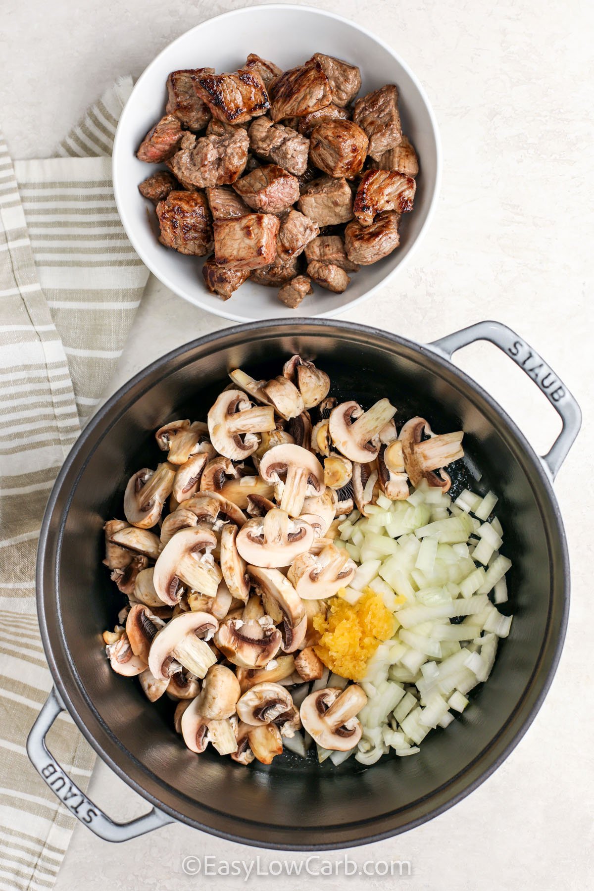 adding mushrooms , onion , garlic to pot to make Low Carb Beef Stew
