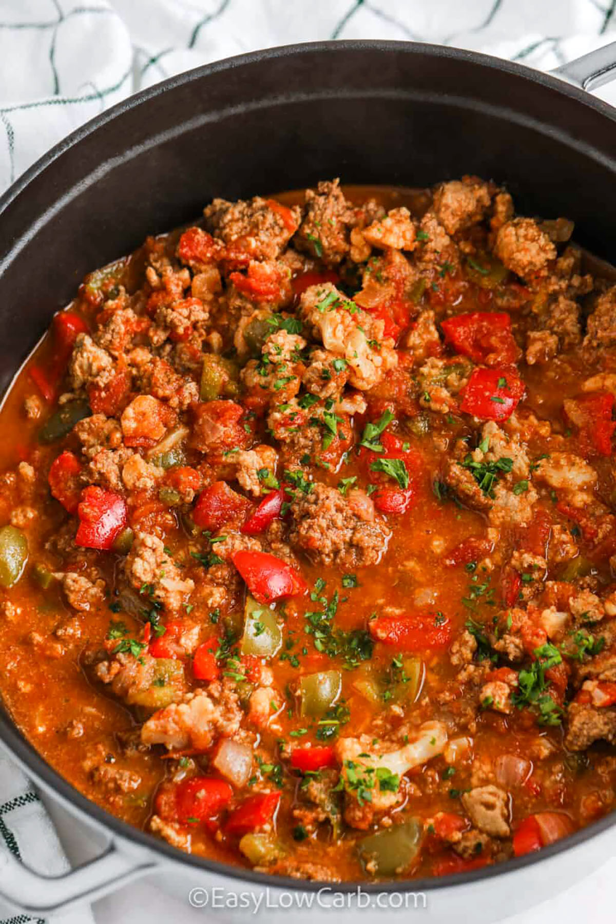 This hearty low carb chili is made with blended cauliflower, ground beef, turkey, tomatoes, and warm spices. It is a hearty and flavorful no-bean dinner. The cauliflower adds texture without carbs, while peppers and jalapeno bring bold flavor. It simmers together in one pot for an easy, healthy meal that works for weeknights or meal prep. Serve it with cheese or sour cream for a cozy bowl everyone will enjoy. #easylowcarb pot full of Low Carb Chili
