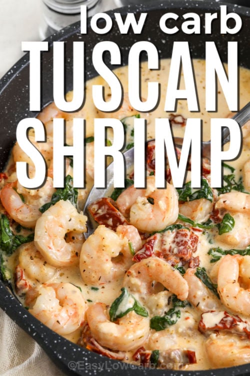 Creamy Tuscan shrimp is a fast one-skillet dinner with juicy shrimp seared in sun-dried tomato oil, then finished in a creamy garlic-Parmesan sauce. Baby spinach wilts right into the pan for a cozy, low carb meal that feels restaurant-worthy. Serve this over zoodles, cauliflower rice, or roasted broccoli for a rich, savory plate with bright tomato flavor. #easylowcarb low carb Creamy Tuscan Shrimp in a pan with writing