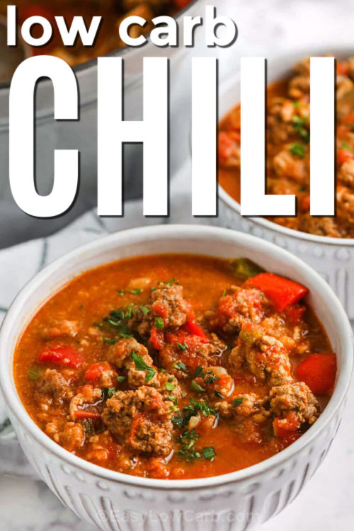 This hearty low carb chili is made with blended cauliflower, ground beef, turkey, tomatoes, and warm spices. It is a hearty and flavorful no-bean dinner. The cauliflower adds texture without carbs, while peppers and jalapeno bring bold flavor. It simmers together in one pot for an easy, healthy meal that works for weeknights or meal prep. Serve it with cheese or sour cream for a cozy bowl everyone will enjoy. #easylowcarb close up of Low Carb Chili in bowls with a title