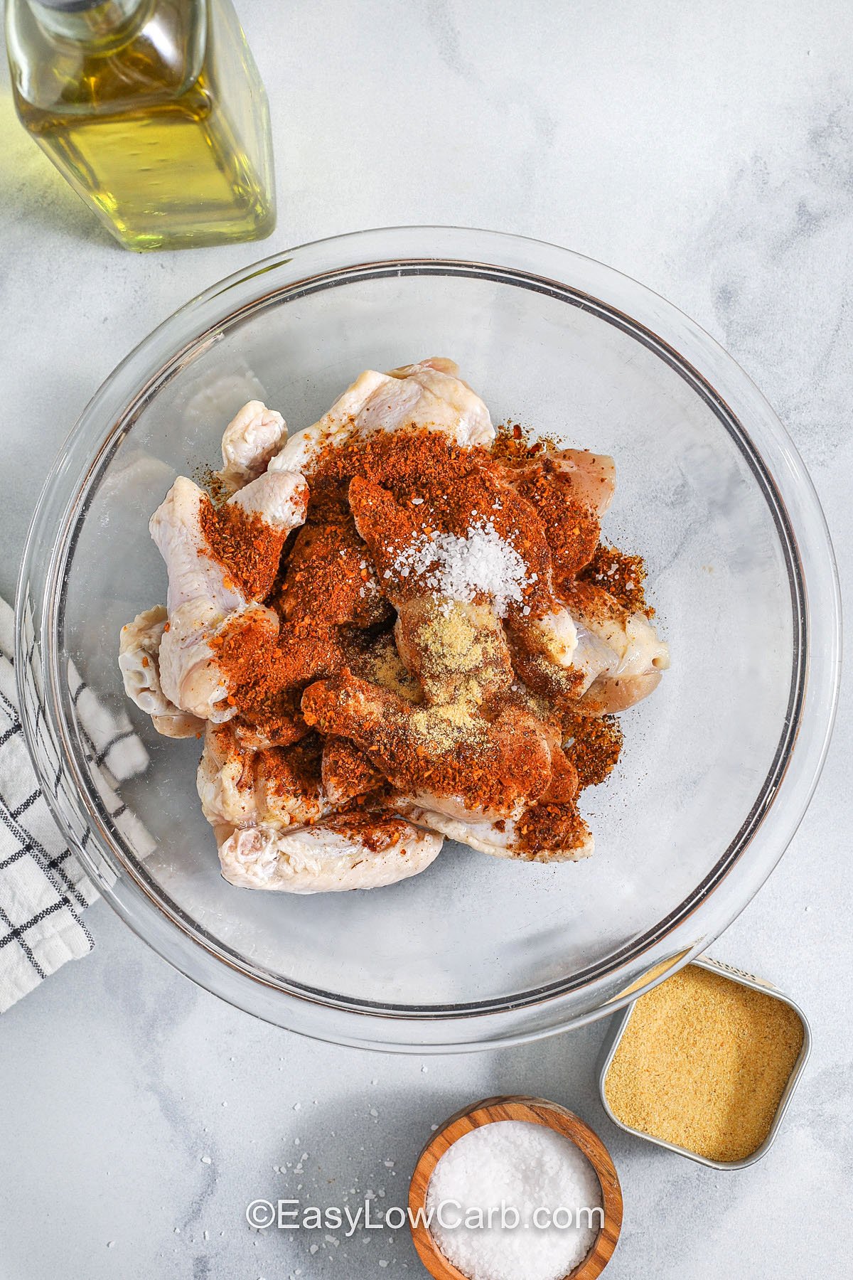 Cajun wings are the ultimate easy upgrade for wing night, delivering bold, smoky heat with crispy skin and no frying required. These oven or air fryer wings use a short ingredient list and simple prep for big flavor without the mess. Just toss, cook, and serve with your favorite dip for a crowd-pleasing appetizer or easy dinner that feels like takeout at home. #easylowcarb cajun wings in a glass bowl with seasonings