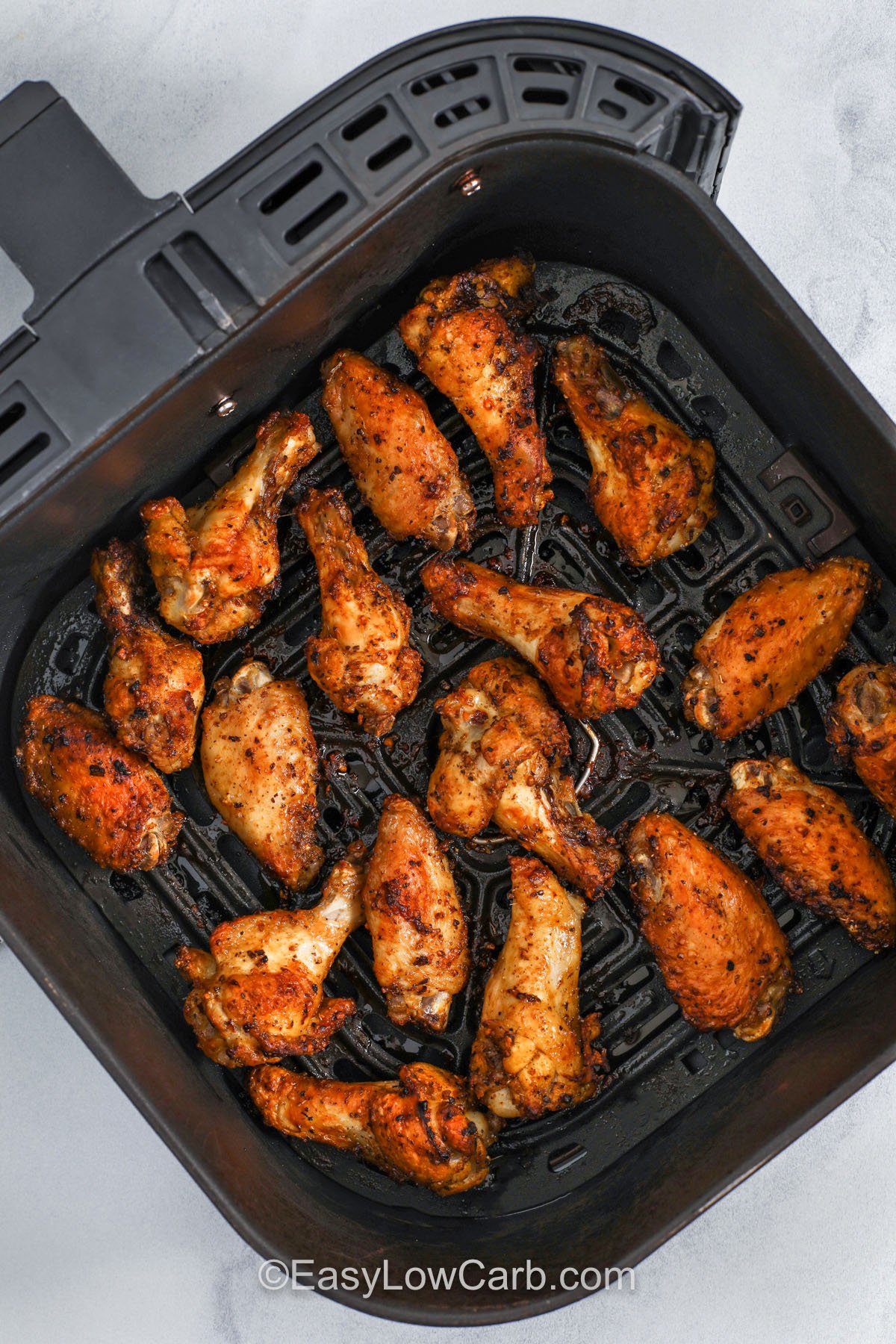 Learn how to make Cajun wings that are crispy, spicy, and easy in either the air fryer or oven. The Cajun dry rub gives a strong flavor with minimal ingredients, and the flip halfway through helps them brown evenly. Serve these low carb chicken wings with ranch or blue cheese and crunchy veggies for a balanced platter that works for parties, snacks, or dinner. #spendwithpennies cajun wings in a air fryer pan