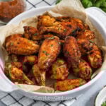 cajun wings in a white bowl with parchment paper