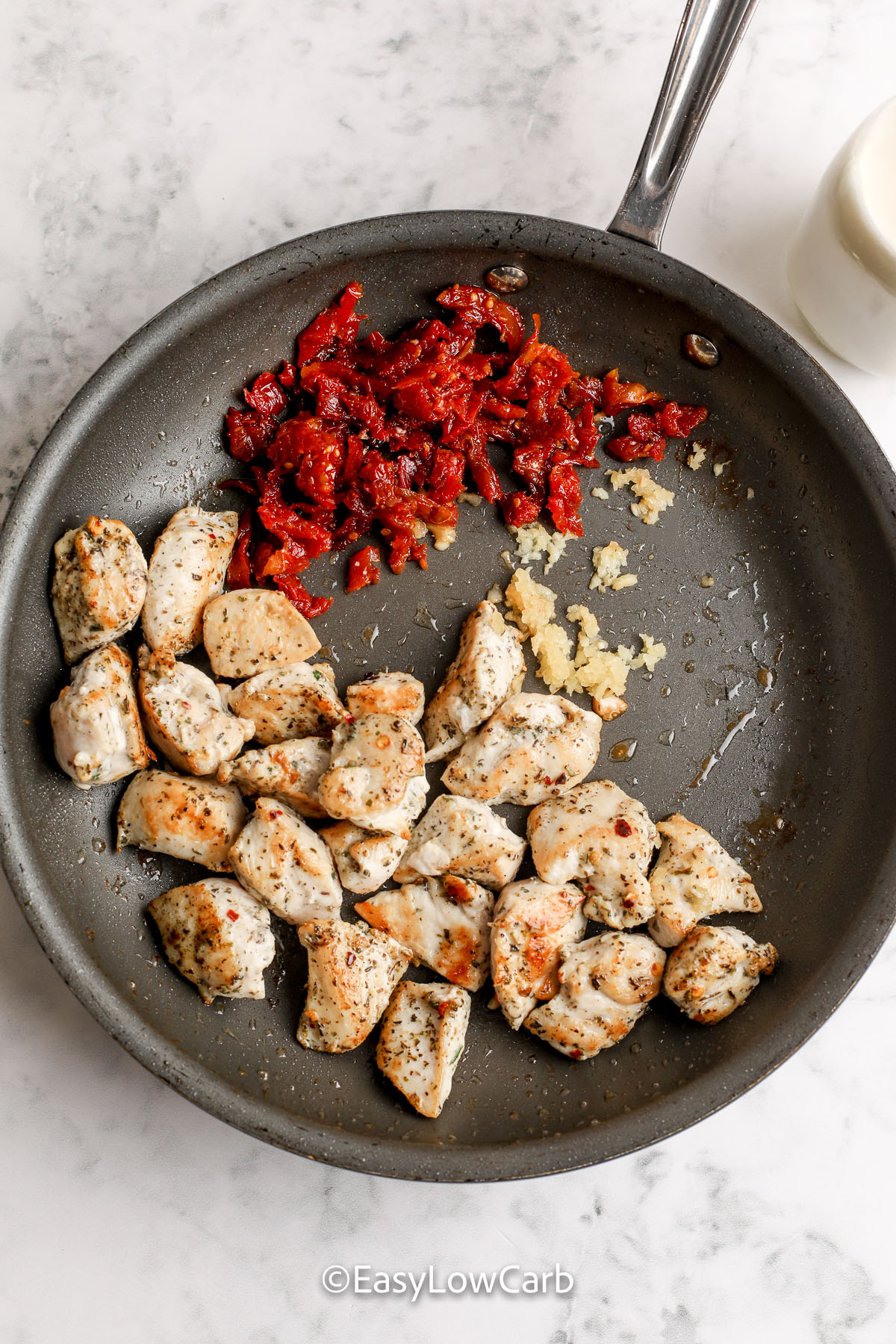 Make creamy Tuscan chicken skillet at home with garlic, parmesan, spinach, and sun-dried tomatoes for bold flavor. The chicken browns first, then finishes cooking in a silky cream sauce so it stays tender. Cauliflower makes it hearty without pasta and keeps it low carb. Use freshly grated Parmesan for smooth melting and a thicker sauce that clings to every bite. #easylowcarb browned chicken, sundried tomatoes and garlic in a skillet