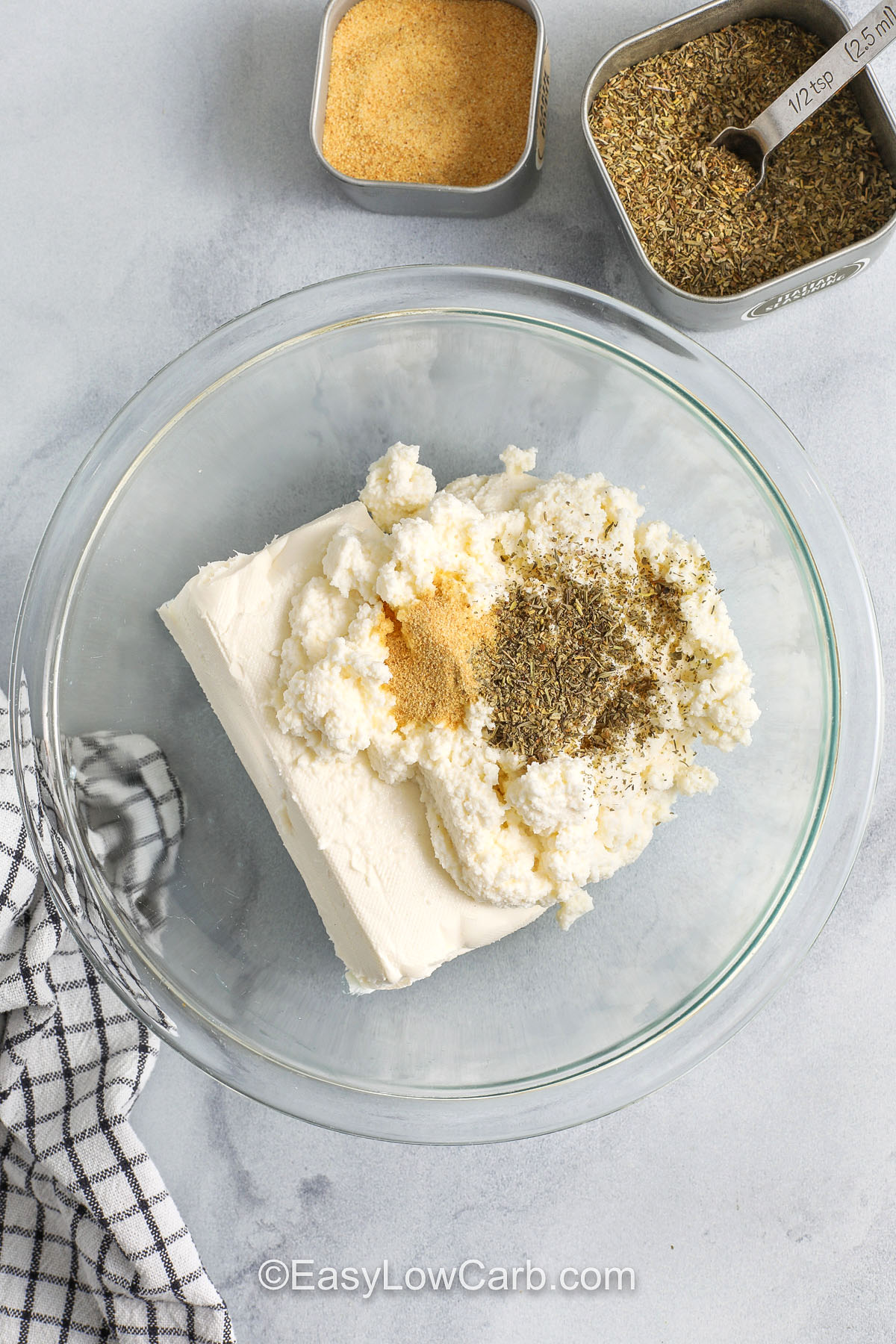 Pepperoni dip is a cozy baked pizza dip that works for parties or a simple snack dinner. The ricotta and cream cheese base stays creamy, while mozzarella and parmesan melt into a golden topping. Pepperoni adds a salty, savory bite that tastes like pizza. Let it rest a few minutes after baking so it thickens for easy scooping, then serve with crunchy veggies. #easylowcarb adding seasonings to cheese to make Pepperoni Dip