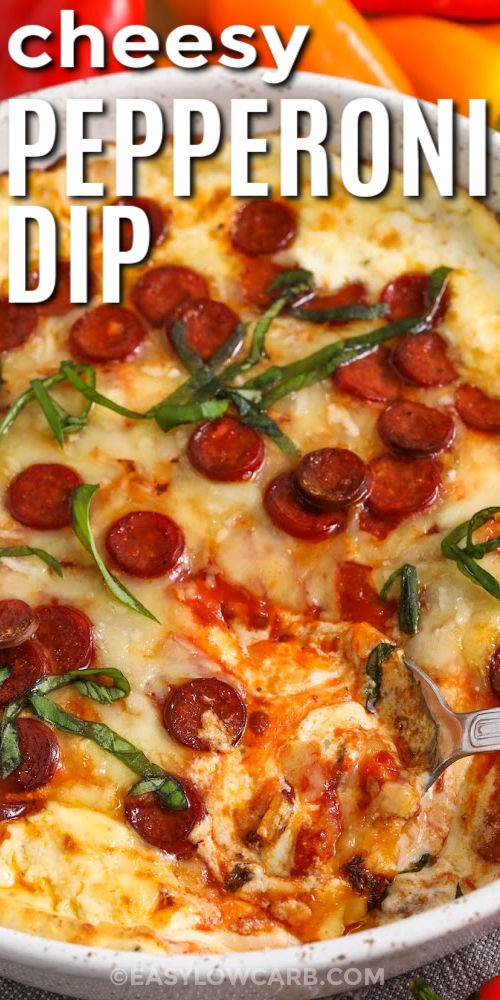 This pepperoni dip bakes into a hot, bubbly appetizer with all the flavors of pizza night. A whipped cream cheese and ricotta base keeps it smooth and scoopable, while low sugar marinara adds tang and mozzarella melts into a stretchy topping. Finish with pepperoni on top for crisp edges. Serve with bell peppers, cucumbers, or low carb crackers for an easy party dip. #easylowcarb close up of cheey Pepperoni Dip with a title