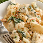 creamy tuscan chicken in a bowl with a fork