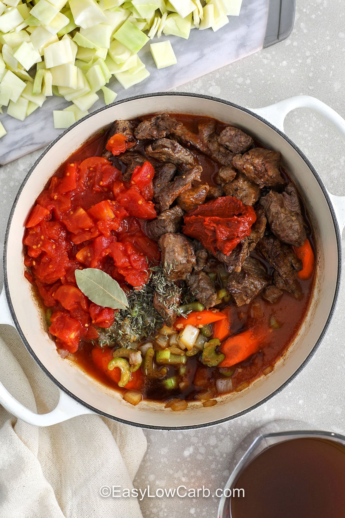 If you love a hearty beef and cabbage soup, this version delivers big flavor with simple ingredients. Chuck roast simmers with beef broth, tomatoes, and tomato paste for a thicker, richer base. Add cabbage after the beef is tender so it keeps the perfect bite. This one pot beef soup is freezer-friendly in portions, so you can stash a few containers for cozy nights when you need dinner fast. #easylowcarb adding ingredients to pot to make Beef and Cabbage Soup
