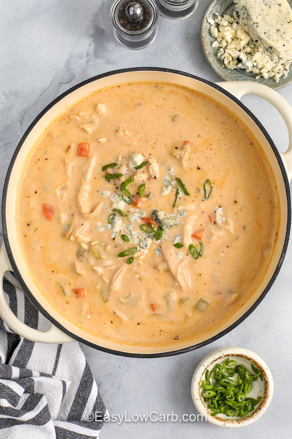 Buffalo chicken soup is perfect for meal prep because it reheats smoothly and stays creamy. The cauliflower base thickens the broth naturally, and cream cheese adds a rich, comforting finish. Stir in shredded chicken and buffalo sauce right before serving so the chicken stays juicy and the flavor stays bright. Garnish with blue cheese and green onions for a bold, savory bowl. #easylowcarb pot of Buffalo Chicken Soup