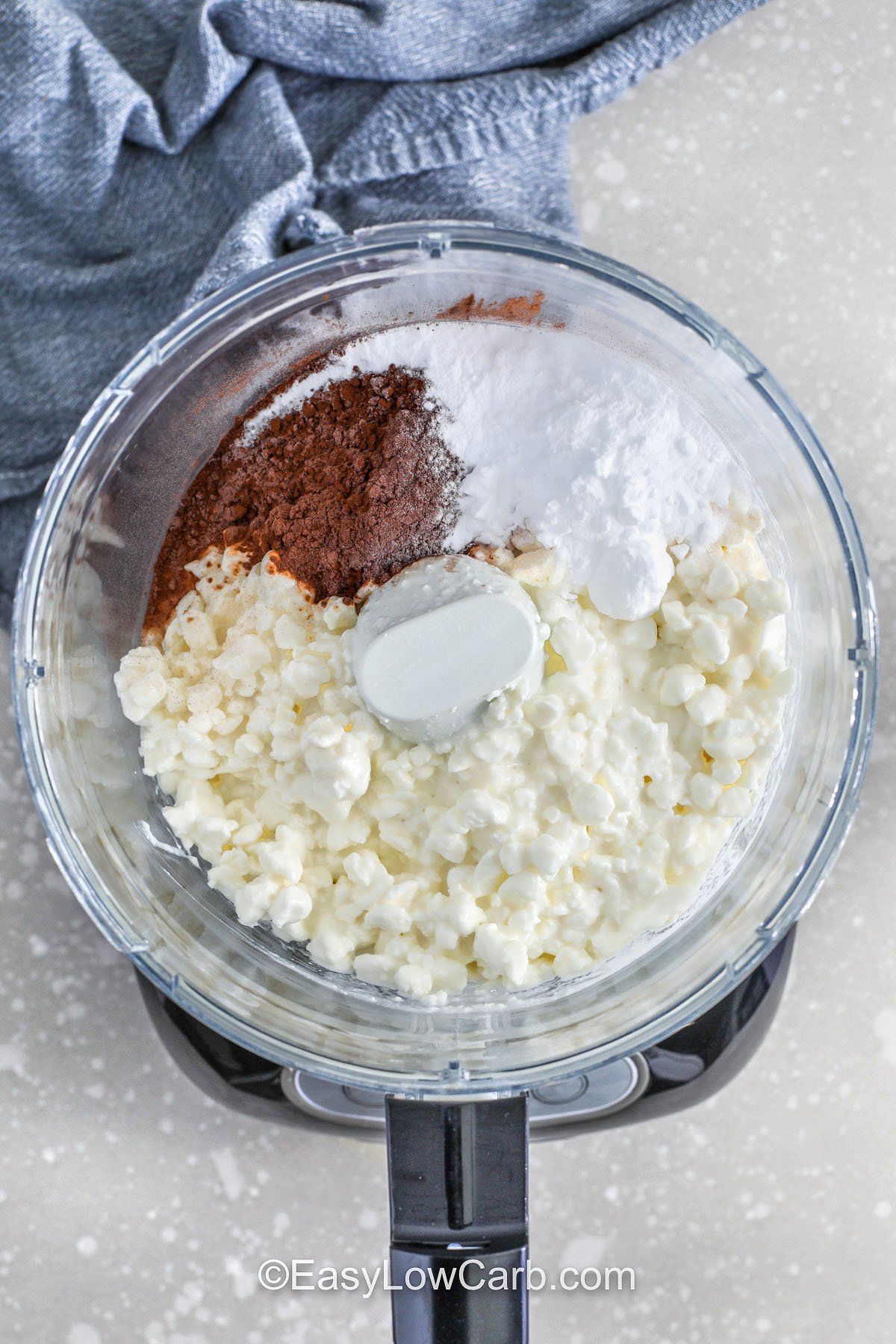 Cottage cheese chocolate mousse is a low carb dessert that turns surprisingly creamy with the right blending. Choose full-fat cottage cheese for the richest flavor, and sift cocoa powder if it is lumpy. A powdered sweetener blends in smoothly, and you can adjust the sweetness after tasting. Chill the mousse to thicken, then serve as a protein dessert cup or layer it into parfait jars with berries. #easylowcarb adding ingredients to food processor to make Cottage Cheese Chocolate Mousse