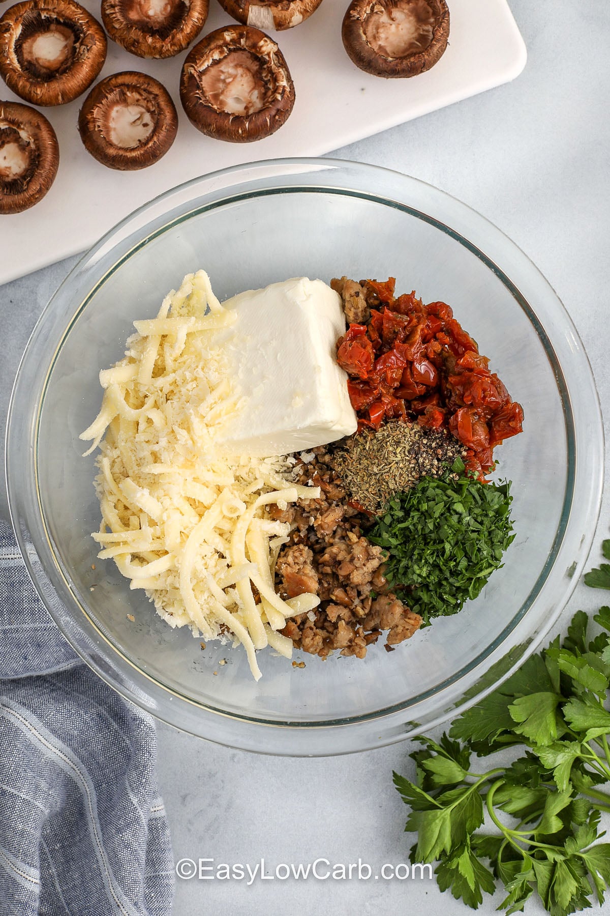 adding ingredients to bowl for filling for Keto Stuffed Mushrooms