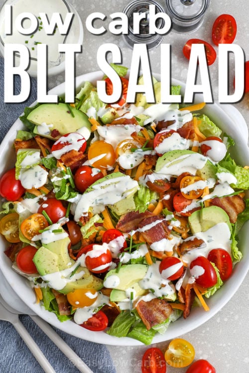 This BLT salad is a low carb way to get all the classic bacon, lettuce, and tomato flavor in one fresh bowl. Crisp romaine, sweet cherry tomatoes, smoky bacon, sharp cheddar, and creamy avocado make it filling enough for lunch or dinner. The BLT salad dressing blends mayo, Greek yogurt, lemon, Dijon, and chives for a tangy drizzle that coats every bite. #easylowcarb blt salad in a white bowl with writing