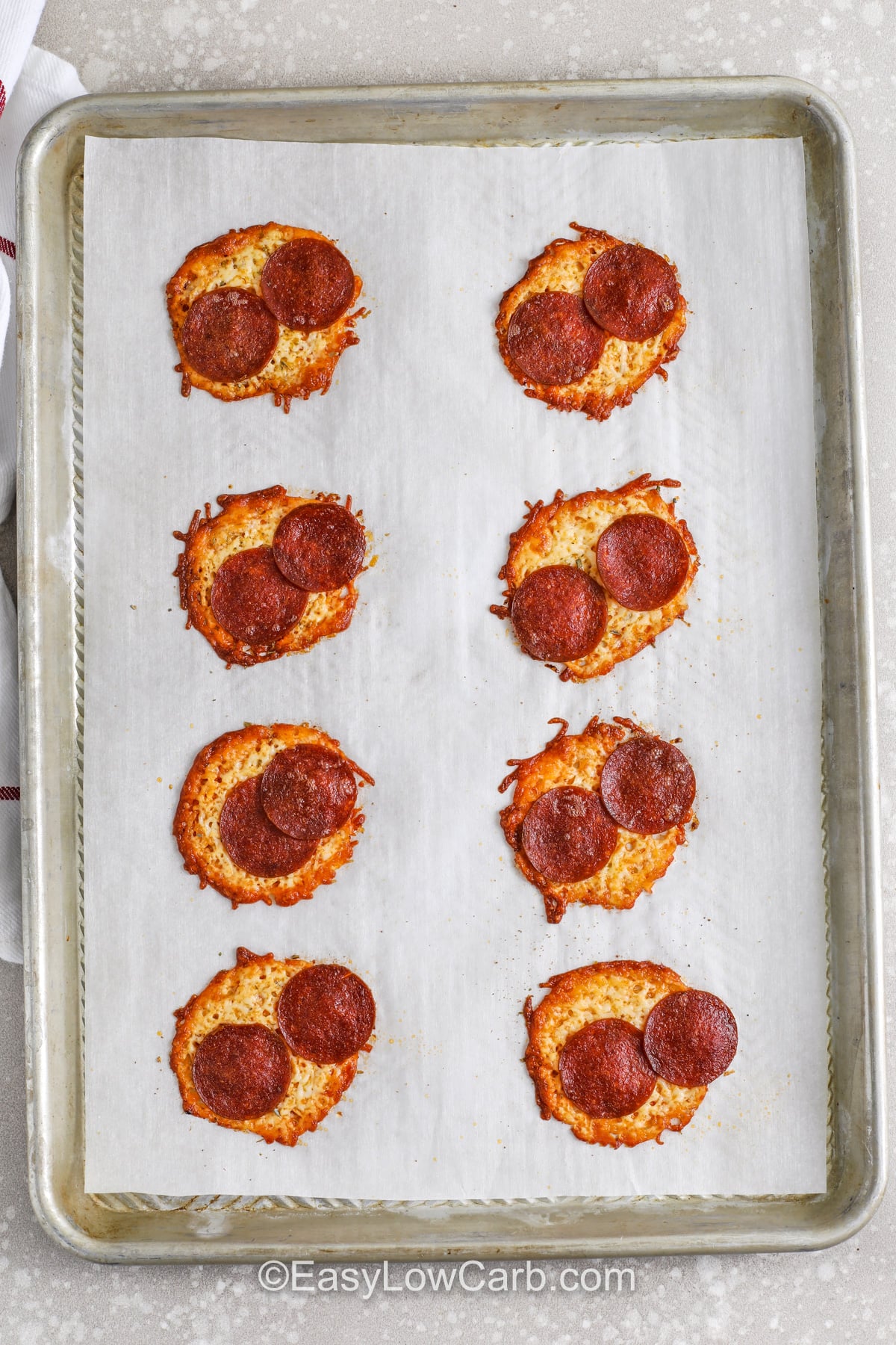 If you love pepperoni pizza but want a quick keto snack, pizza chips are the move. Shredded mozzarella melts into chip-sized rounds, pepperoni adds salty bite, and garlic powder plus oregano makes it taste like a slice. Bake on parchment so cleanup is easy, and let them cool fully to crisp. Dip in low carb marinara sauce for a simple, crunchy snack that disappears fast. #easylowcarb cooked Pizza Chips on a sheet pan