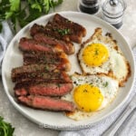 plated sliced Steak and Eggs Breakfast with a fork