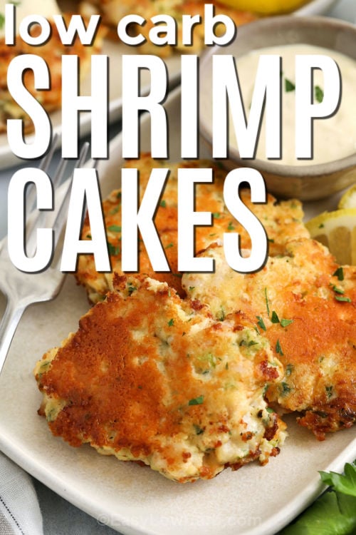 These shrimp cakes are a simple skillet recipe that turns raw shrimp, Dijon, parsley, and parmesan into a crisp, flavorful meal. Finely chopped shrimp gives them a tender texture, while almond flour keeps them low carb and helps them hold together. Serve these shrimp cakes with lemon aioli and a fresh salad for an easy dinner that feels polished but still practical for a busy night. #easylowcarb low carb Shrimp Cakes on a plate with writing