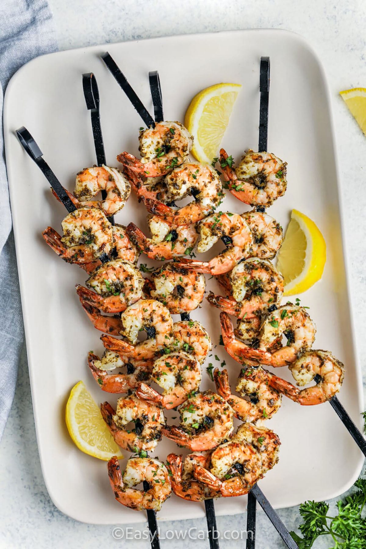 Looking for a shrimp kabob recipe that is simple and full of flavor. These easy grilled shrimp skewers are loaded with juicy shrimp and fresh vegetables. They make a healthy dinner that works for busy weeknights and outdoor gatherings. The fresh ingredients and smoky grill flavor make every bite delicious. Pair them with cauliflower rice or your favorite salad for an easy meal. Family and friends will love these colorful skewers. Fire up the grill and make them soon. #easylowcarb plated Grilled Shrimp Kabobs with lemon
