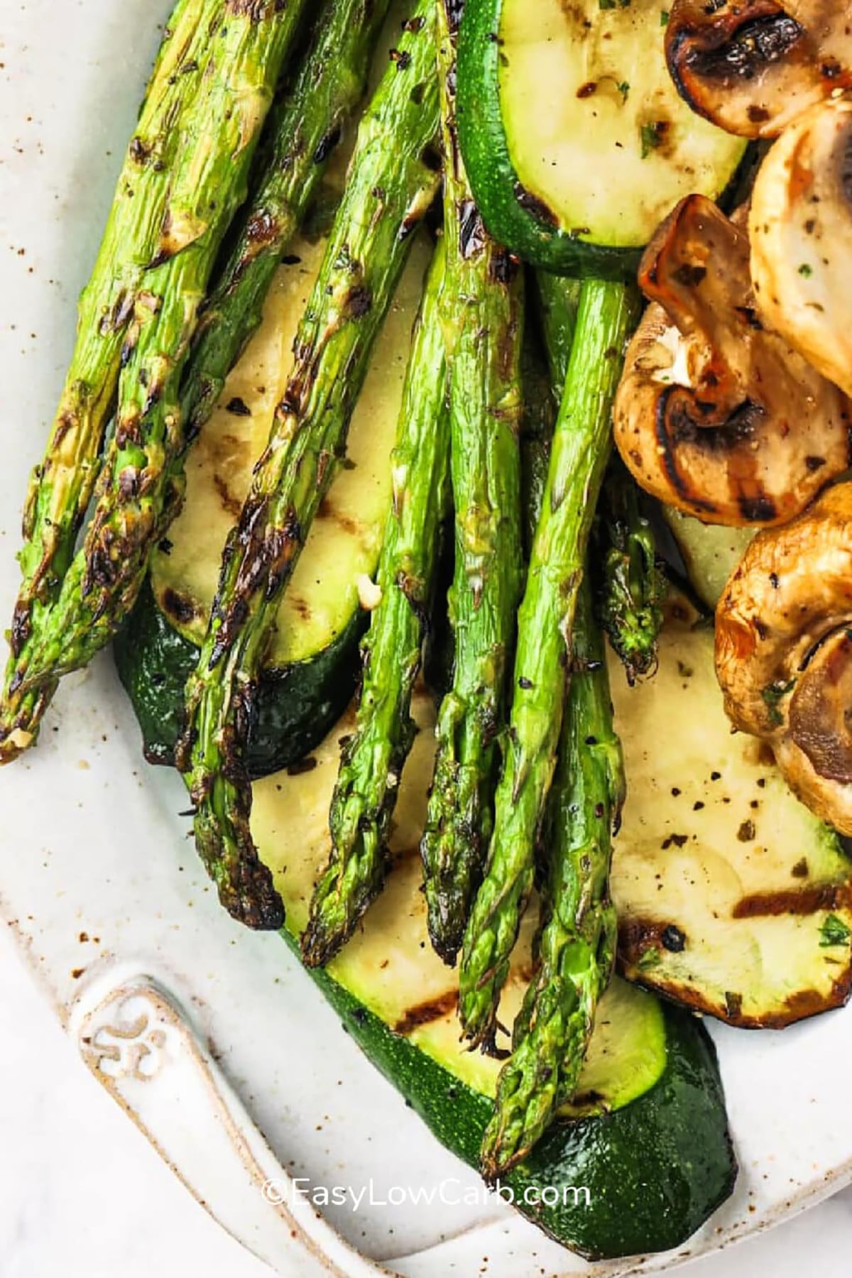 Weeknight cooking feels simple with a grilled vegetables recipe that delivers big flavor fast. Fresh vegetables like zucchini, mushrooms, and asparagus are marinated in garlic, balsamic vinegar, and seasonings, then grilled until tender and lightly charred. This healthy side dish is perfect for BBQ spreads or easy family dinners. It brings fresh, smoky flavor to any plate without extra effort. Save this recipe and make it soon. #easylowcarb Grilled Vegetables Recipe on a plate