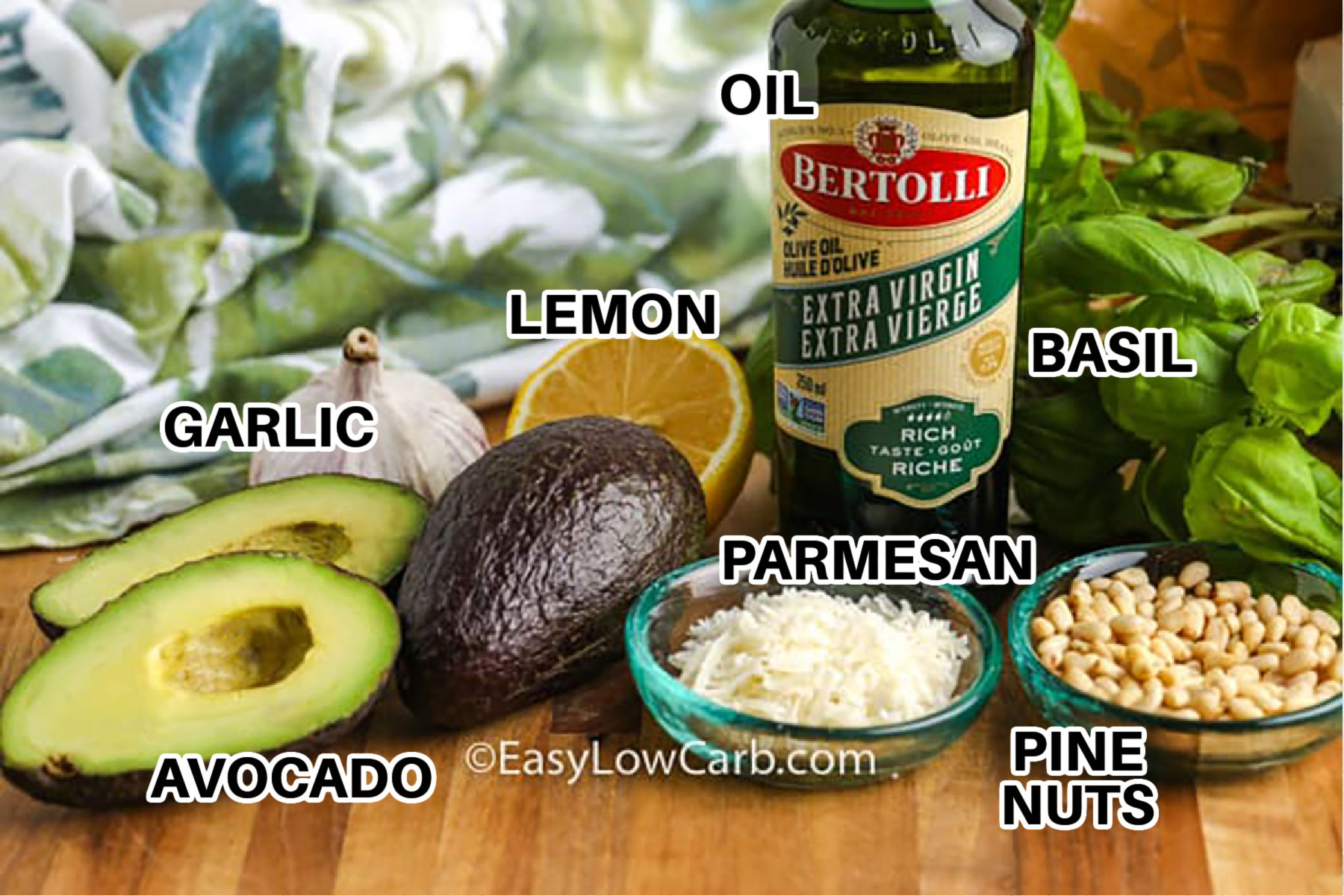 This avocado pesto is creamy, fresh, and full of bright basil flavor with ripe avocado, garlic, lemon juice, parmesan, pine nuts, and olive oil. It comes together quickly in a food processor and makes a delicious low carb sauce for zoodles, grilled chicken, salmon, eggs, or roasted vegetables. The avocado gives it a silky texture while keeping the flavor light and fresh. #easylowcarb oil , lemon , basil , parmesan , pine nuts , garlic , avocado with labels to make Avocado Pesto