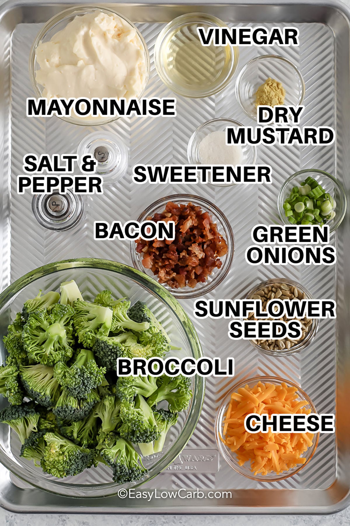 This easy keto broccoli salad recipe is a fast and tasty addition to any meal. With only five ingredients, it's simple to prepare and bursting with flavor. Featuring crunchy broccoli, cheese, nuts, bacon bits, and green onions, all covered in a creamy mustard dressing, it's a delicious treat. Pin this recipe to keep a low-carb salad ready for busy weeks. #easylowcarb mayonnaise , vinegar , dry mustard , sweetener , bacon , green onions , sunflower seeds , cheese , broccoli , salt and pepper with labels to make Keto Broccoli Salad
