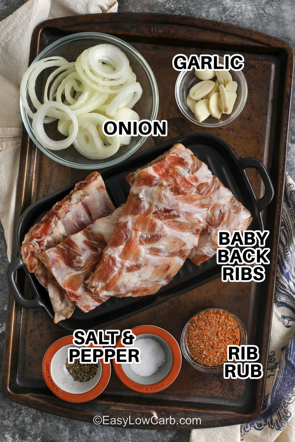 An oven baked ribs recipe like this gives you smoky barbecue flavor and tender ribs without needing a grill or smoker. The baby back ribs bake slowly with a savory spice rub, sliced onion, and garlic for rich flavor in every bite. Finish them under the broiler for caramelized edges and sticky low-carb BBQ sauce that tastes great with simple side dishes. These fall-off-the-bone ribs are easy enough for any night of the week. Make this recipe for dinner tonight. #easylowcarb onion , garlic , baby back ribs , rib bun , salt and pepper with labels to make Oven Baked Ribs