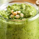 close up of Avocado Pesto in a jar with pine nuts