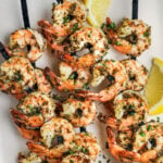 close up of Grilled Shrimp Kabobs on a plate with lemon slices