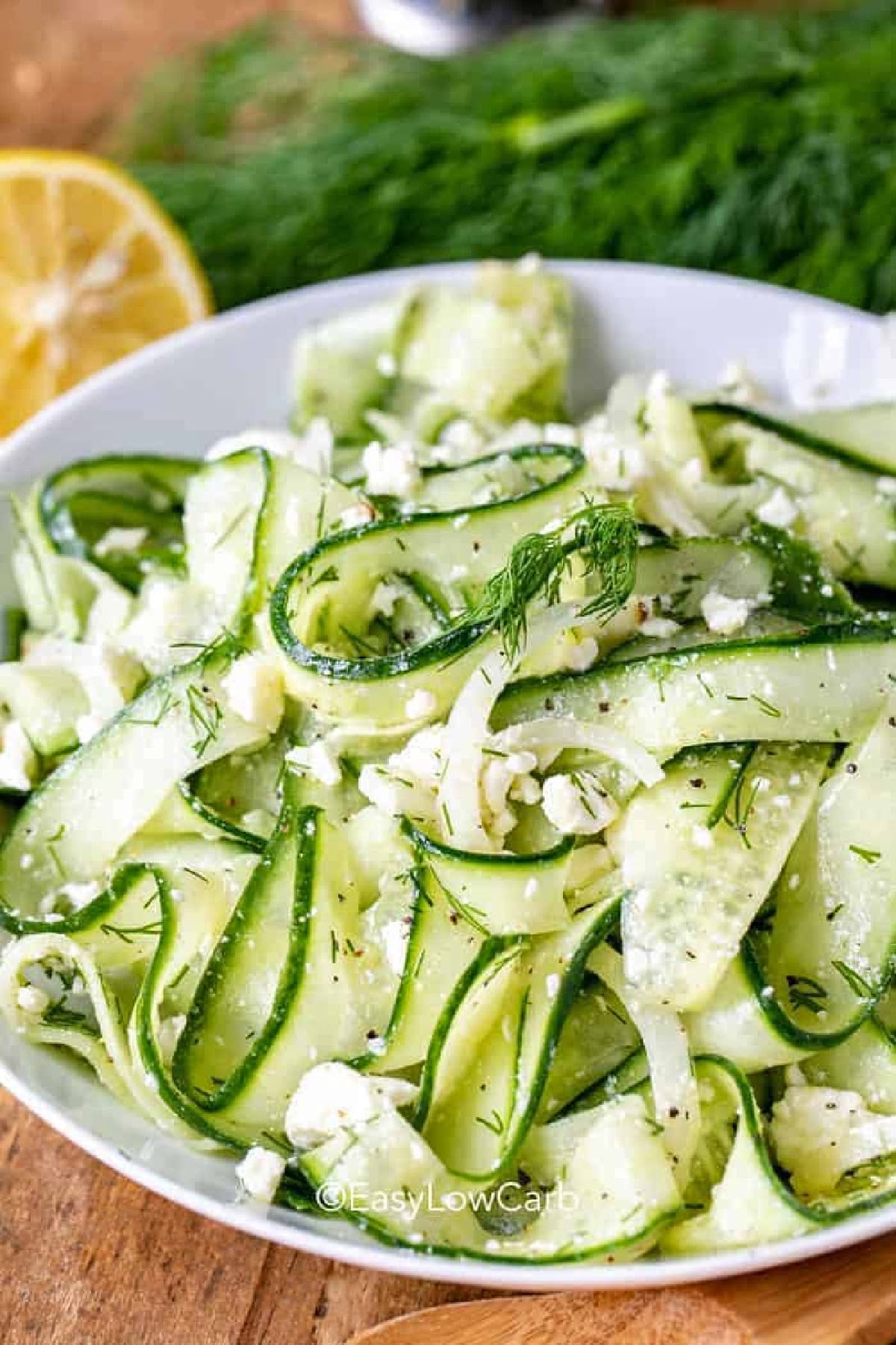 Cucumber feta salad adds fresh flavor and crisp texture to any meal. Every bite combines cool cucumber ribbons with a light lemon dill dressing and salty feta cheese for a side dish that tastes as good as it looks. It is an easy cucumber salad recipe that fits right in with summer dinners, picnics, and holiday spreads. Save this recipe and give it a place on your table. #theshortcutkitchen bowl of Cucumber Feta Salad