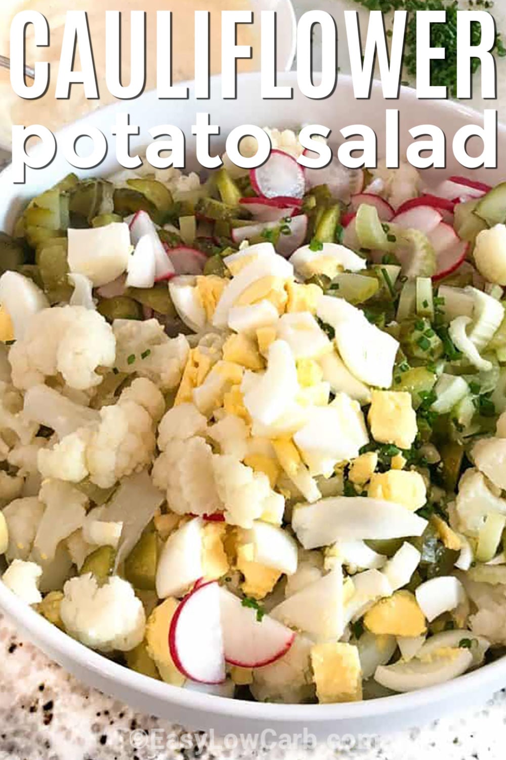 Love cauliflower potato salad when you are craving a classic side with fewer carbs. This cauliflower mock potato salad combines tender cauliflower with crunchy vegetables, chopped eggs, and a creamy mustard dressing for a fresh take on an old favorite. It is perfect for barbecues, potlucks, meal prep, or weeknight dinners, and everyone will want another helping. Make it for your next meal and enjoy every bite. #easylowcarb bowl of Cauliflower Potato Salad with writing