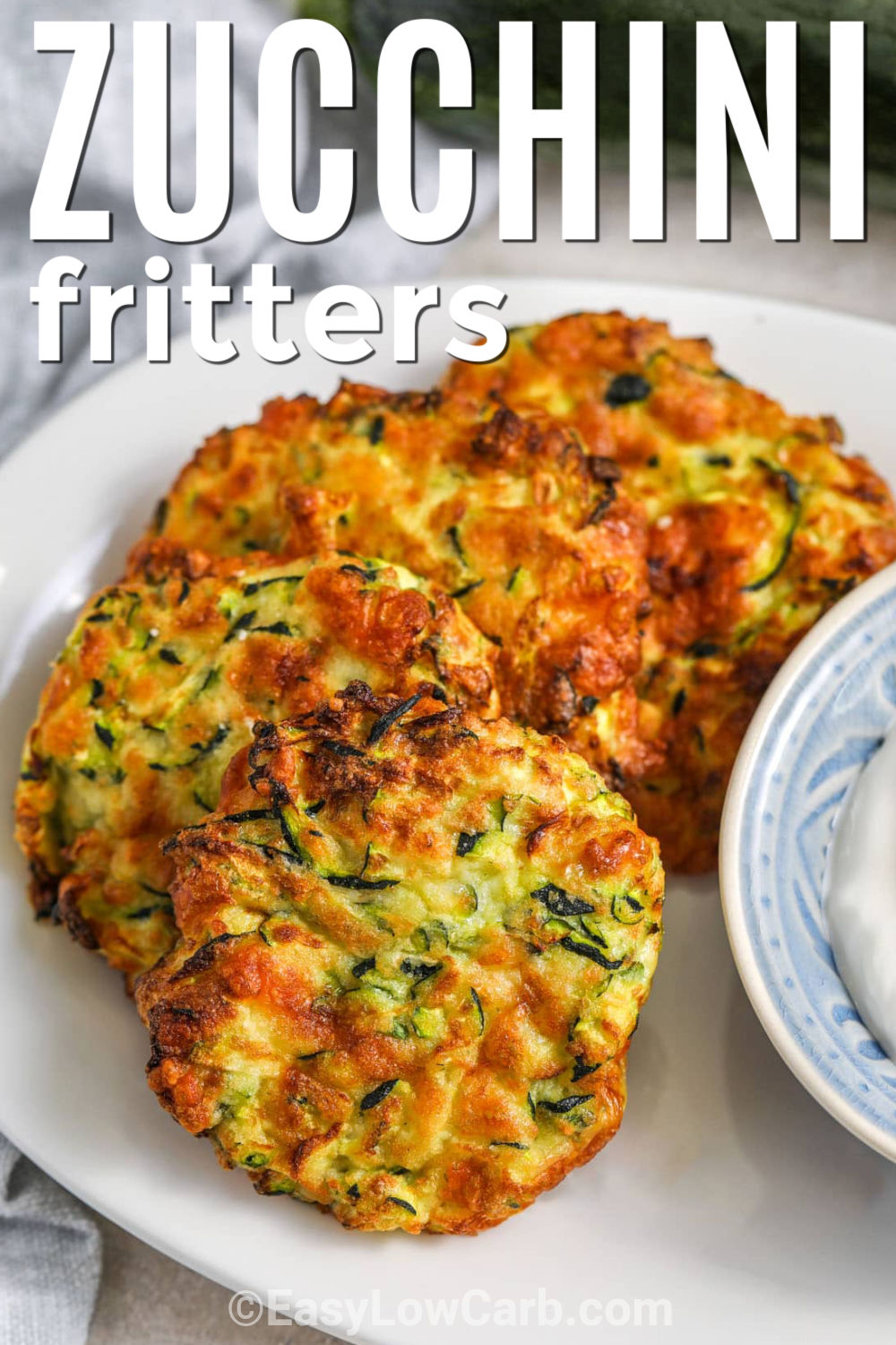 Are you looking for a zucchini fritter recipe that is easy and full of flavor? These crispy zucchini fritters are made with shredded zucchini, mozzarella, Parmesan, and green onion for a delicious bite every time. They are low carb, family-friendly, and great as an appetizer or side dish. You can even cook them in the air fryer for another tasty option. Give this recipe a try today. #easylowcarb plate of Zucchini Fritters with a title