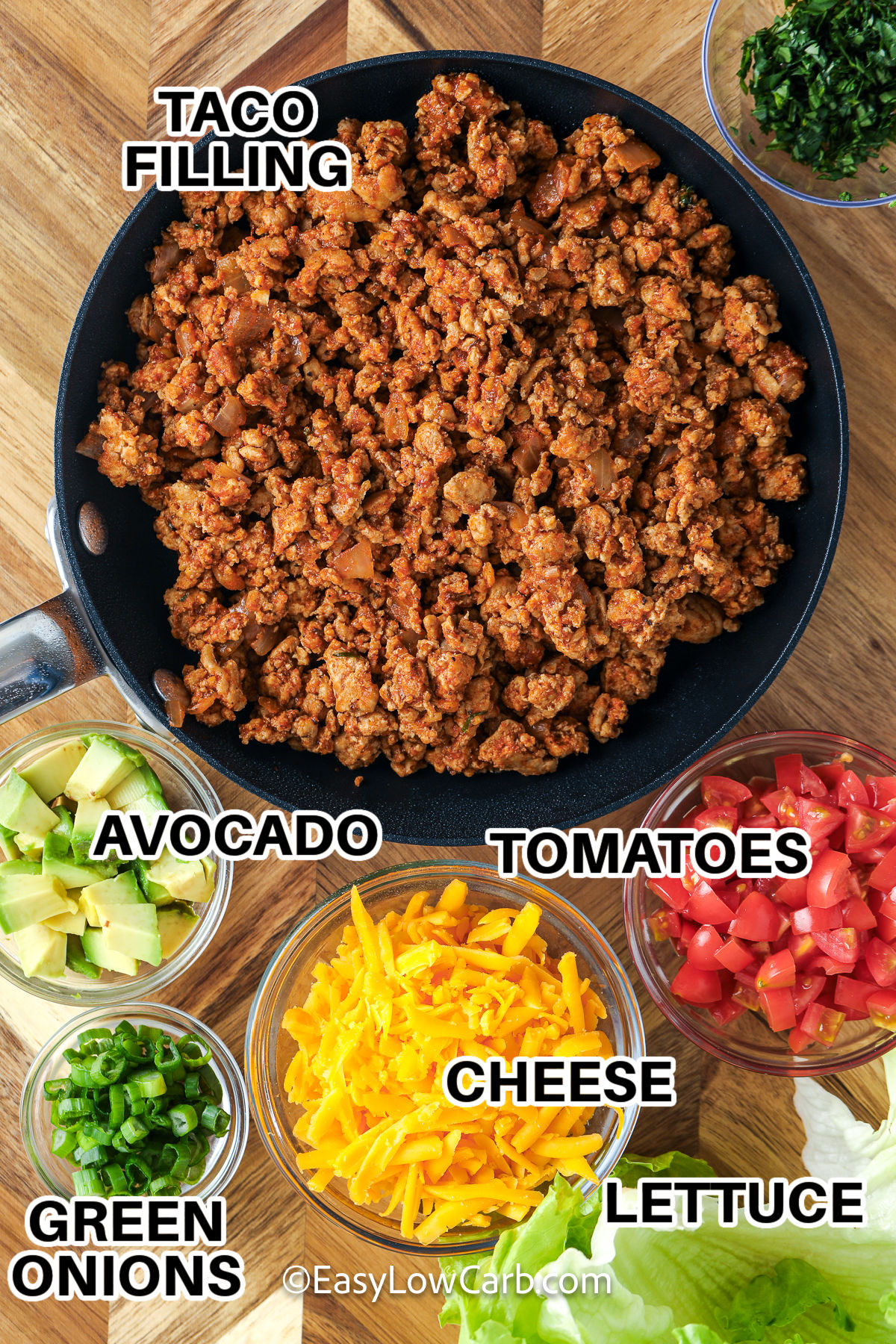 Taco lettuce wraps make it easy to enjoy bold Mexican inspired flavors with a fresh and crunchy twist. Every bite is filled with seasoned beef, salsa, and all the toppings you love for a meal that is hearty without feeling heavy. They are simple to customize for every member of the family and perfect for serving any night of the week. Make them today and enjoy every bite. #easylowcarb taco filling , tomatoes , cheese , avocado , green onions , lettuce with labels to make Taco Lettuce Wraps