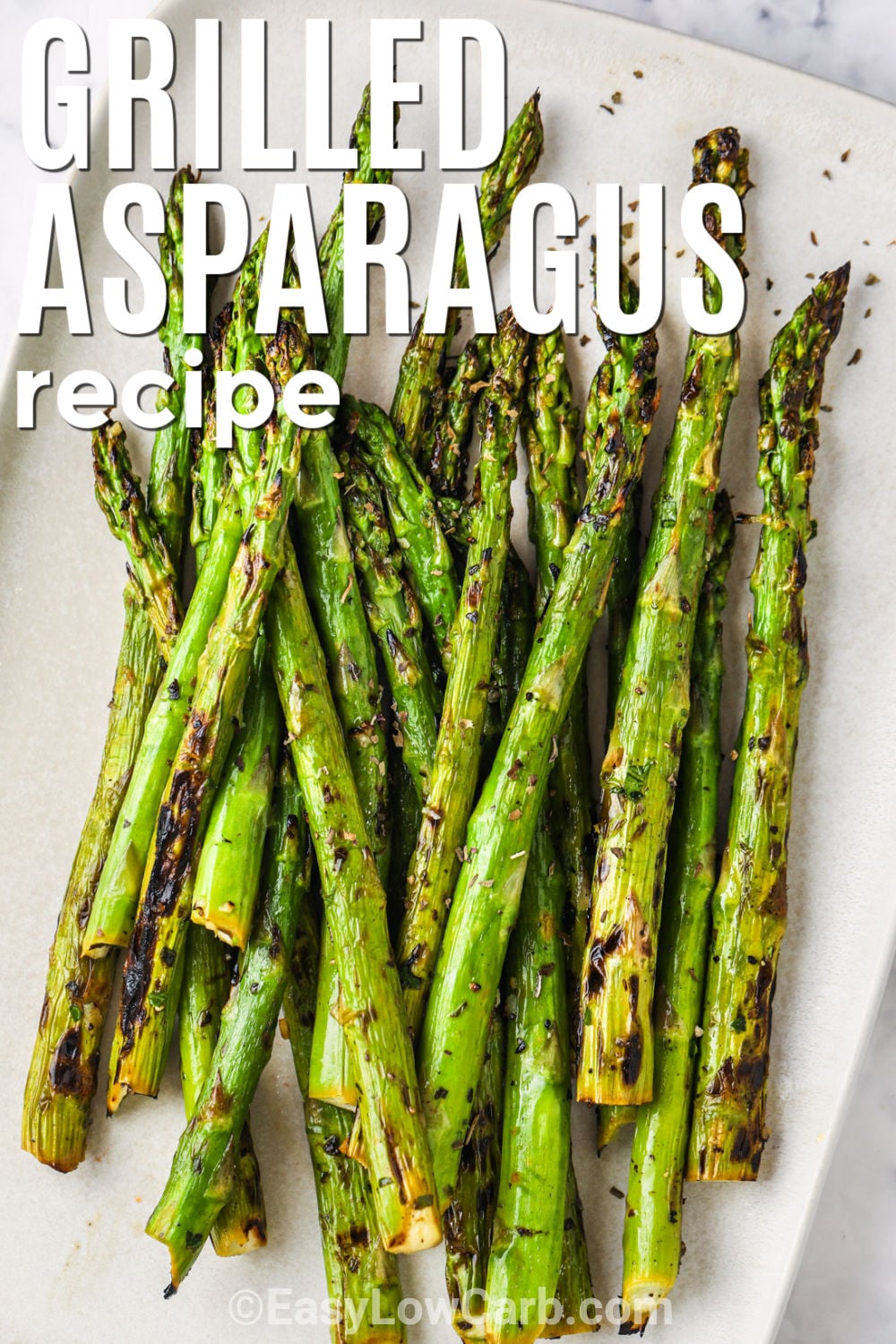 Grilled asparagus recipe brings big flavor to a simple vegetable with just a few pantry staples. The asparagus cooks right on the grill until tender-crisp, with a delicious smoky flavor and lightly browned edges. A little lemon juice keeps the dish bright and fresh without making it complicated. It is a great low carb side for grilled meats, fish, or casual family dinners. Add this easy vegetable recipe to your menu and enjoy it soon. #easylowcarb plate of Grilled Asparagus Recipe with a title