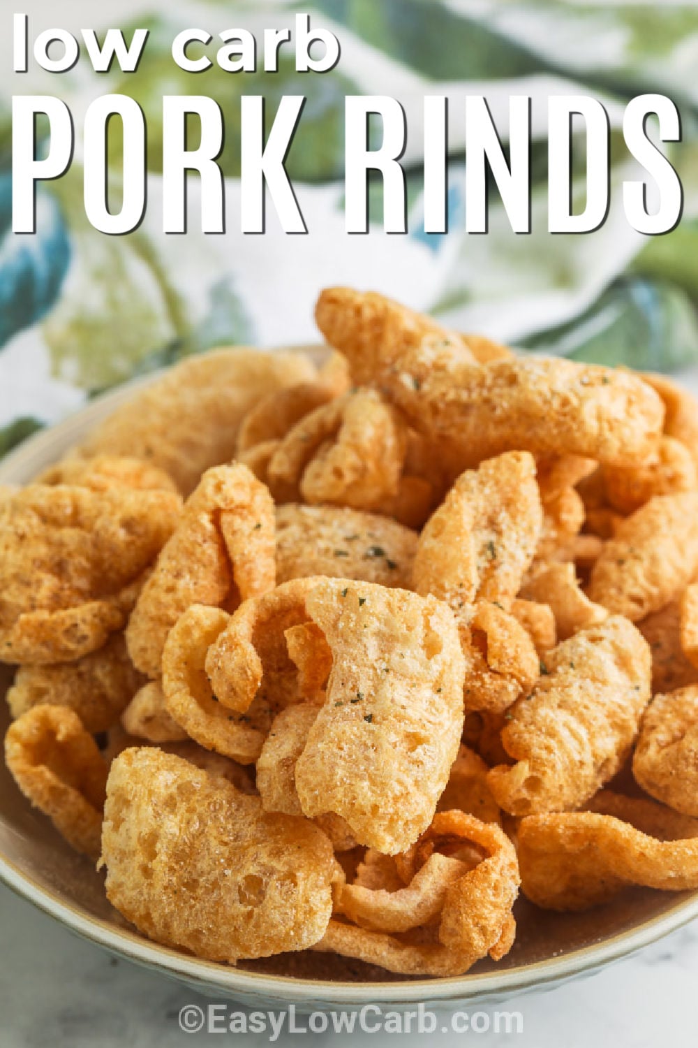 Pork rinds get even better with this easy air fryer recipe and a savory ranch seasoning. Every bite is light, crispy, and packed with bold flavor that makes this a favorite low carb snack. They are perfect for game day, movie night, or whenever you want something crunchy without reaching for chips. Keep this simple keto snack in your recipe collection and enjoy it again and again. Try it today. #easylowcarb low carb Ranch Pork Rinds in a bowl with writing