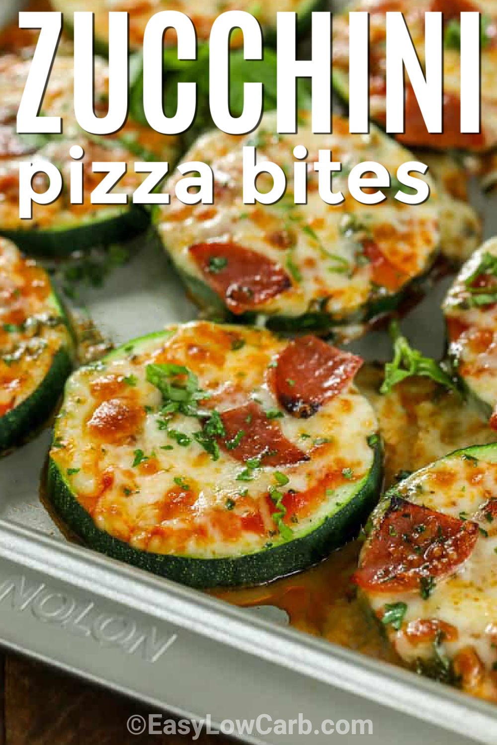 These baked zucchini pizza bites combine tender zucchini with tomato sauce and plenty of melted mozzarella. Parmesan and oregano add bold pizzeria flavor, while pepperoni or finely chopped vegetables make each bite easy to personalize. The simple baking and broiling method gives the cheese a lightly browned finish. Pin this low carb zucchini appetizer for parties, casual lunches, summer snacking, or pizza night. #easylowcarb Zucchini Pizza Bites on a sheet pan with writing