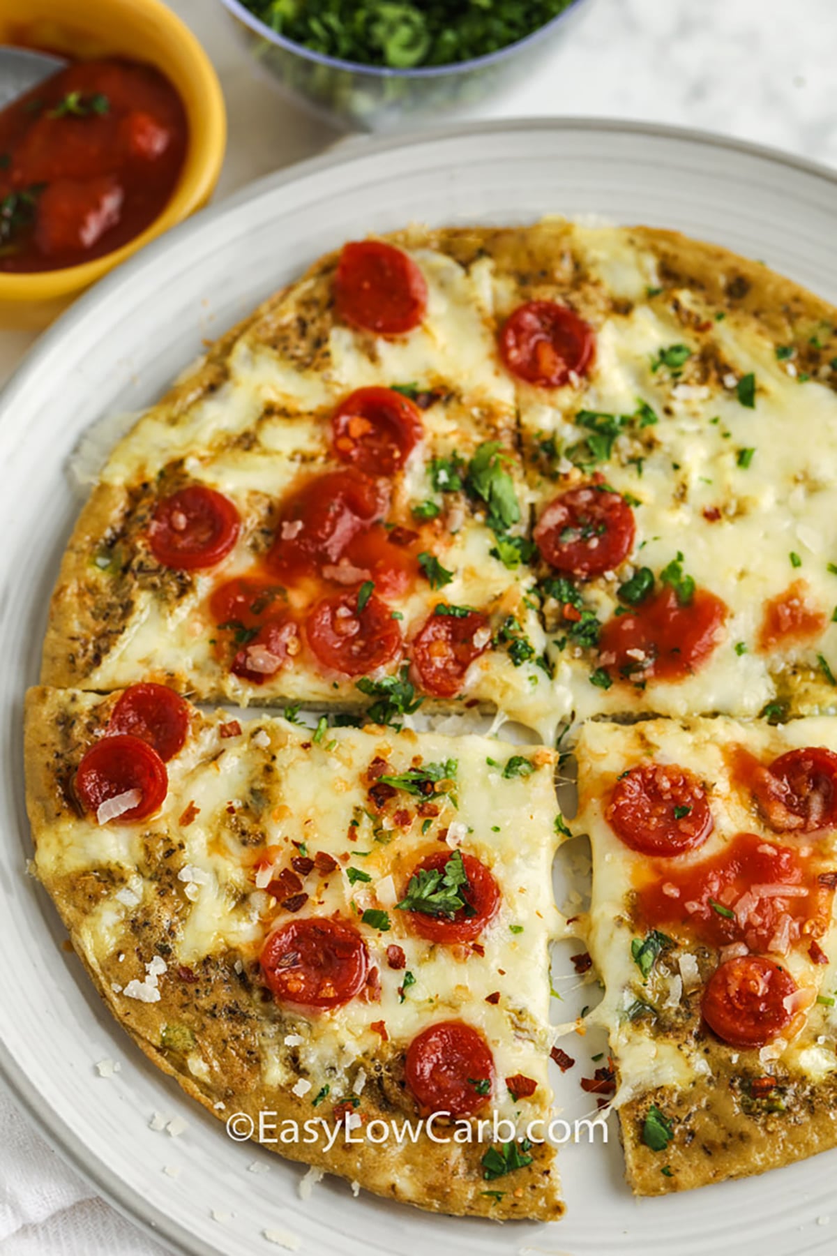 This keto breakfast pizza is a simple way to turn everyday eggs into a hot, cheesy meal with plenty of pepperoni pizza flavor. Green pepper or mushrooms cook first, followed by a creamy egg base and a topping of mozzarella and pepperoni. A quick finish under the broiler melts the cheese without requiring a separate crust or baking pan. Save this easy skillet breakfast for mornings when plain eggs will not do. #easylowcarb plated Keto Breakfast Pizza