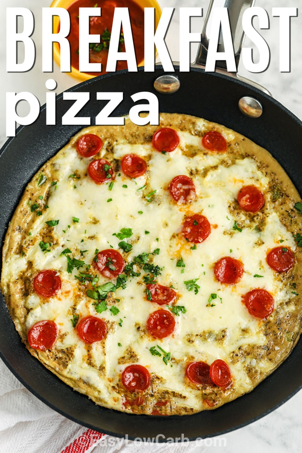 Warm, savory, and covered in melted cheese, this keto breakfast pizza makes a satisfying meal without a traditional pizza crust. Two eggs cook gently in a skillet before getting topped with pepperoni and mozzarella and finished under the broiler. It is quick enough for a weekday and easy to customize with whatever keto-friendly pizza toppings are on hand. Pin this 15-minute breakfast for your next meal plan. #easylowcarb Keto Breakfast Pizza in a pan with writing