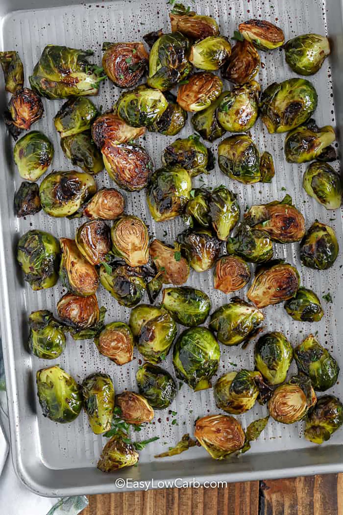 Low carb roasted Brussels sprouts can be simple and full of flavor with the right roasting technique. Fresh Brussels sprouts are halved and coated in olive oil, garlic, and balsamic vinegar before roasting until tender with caramelized edges. This easy vegetable side needs just a few ingredients, pairs with many main dishes, and reheats well for meal prep lunches or dinners. Save these roasted Brussels sprouts for a quick low carb side. #easylowcarb Easy Roasted Brussels Sprouts cooked on a sheet pan.