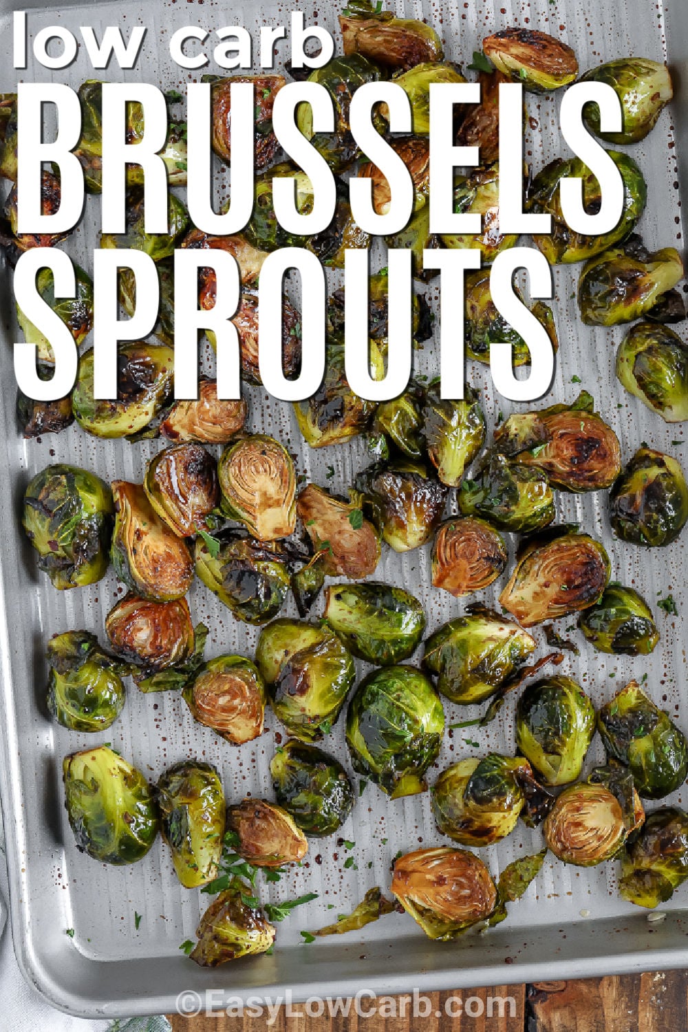 Roasted Brussels sprouts are an easy low carb side with tender centers, caramelized edges, and plenty of savory flavor. Fresh Brussels sprouts are coated with olive oil, balsamic vinegar, and garlic before roasting cut-side down for better browning. This simple 30-minute vegetable works with chicken, pork, steak, or a holiday roast and requires only a few everyday ingredients. Save this recipe for your next easy dinner side. #easylowcarb low carb Easy Roasted Brussels Sprouts with writing .